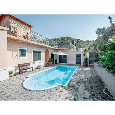 Glasfiberpool Aves med romersk trappa i rektangulär form med kurvad ände, klarblått vatten och vita kakelkanter