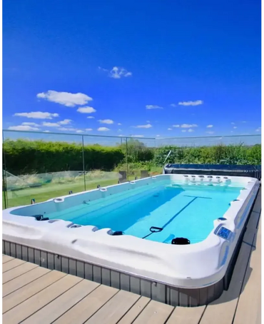 PassionSpa Fitness 1 Swim Spa med vit rektangulär form, blått vatten och grå kakelbas