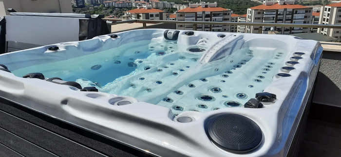 Hot tub – white finish, black accents, massage jets, clear blue water