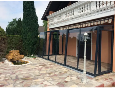 Patio enclosure – black frame, roof with clear panels, for a pool and patio