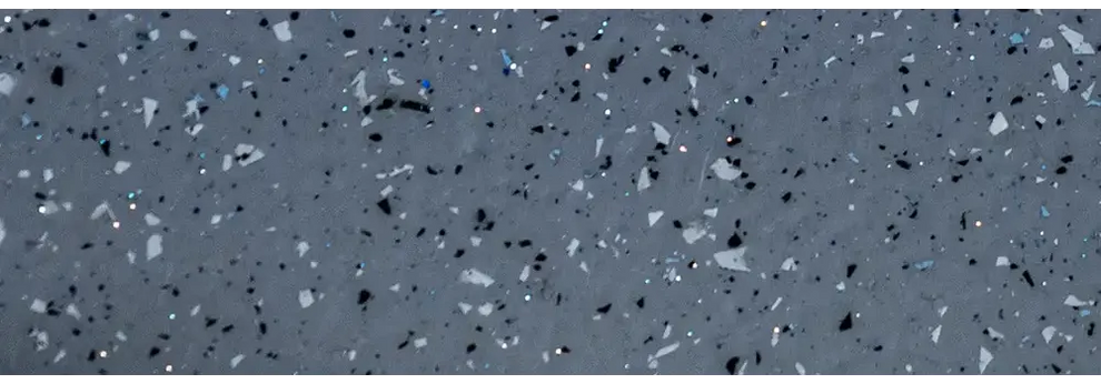 Grå terrazzo med svarta, vita och blå fläckar vid blå rektangulär glasfiberpool Aruba