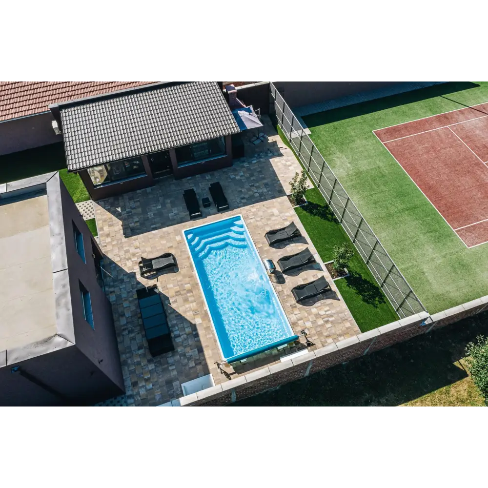 Blå rektangulär glasfiberpool Aruba med kaklade kanter och vattenrullningar