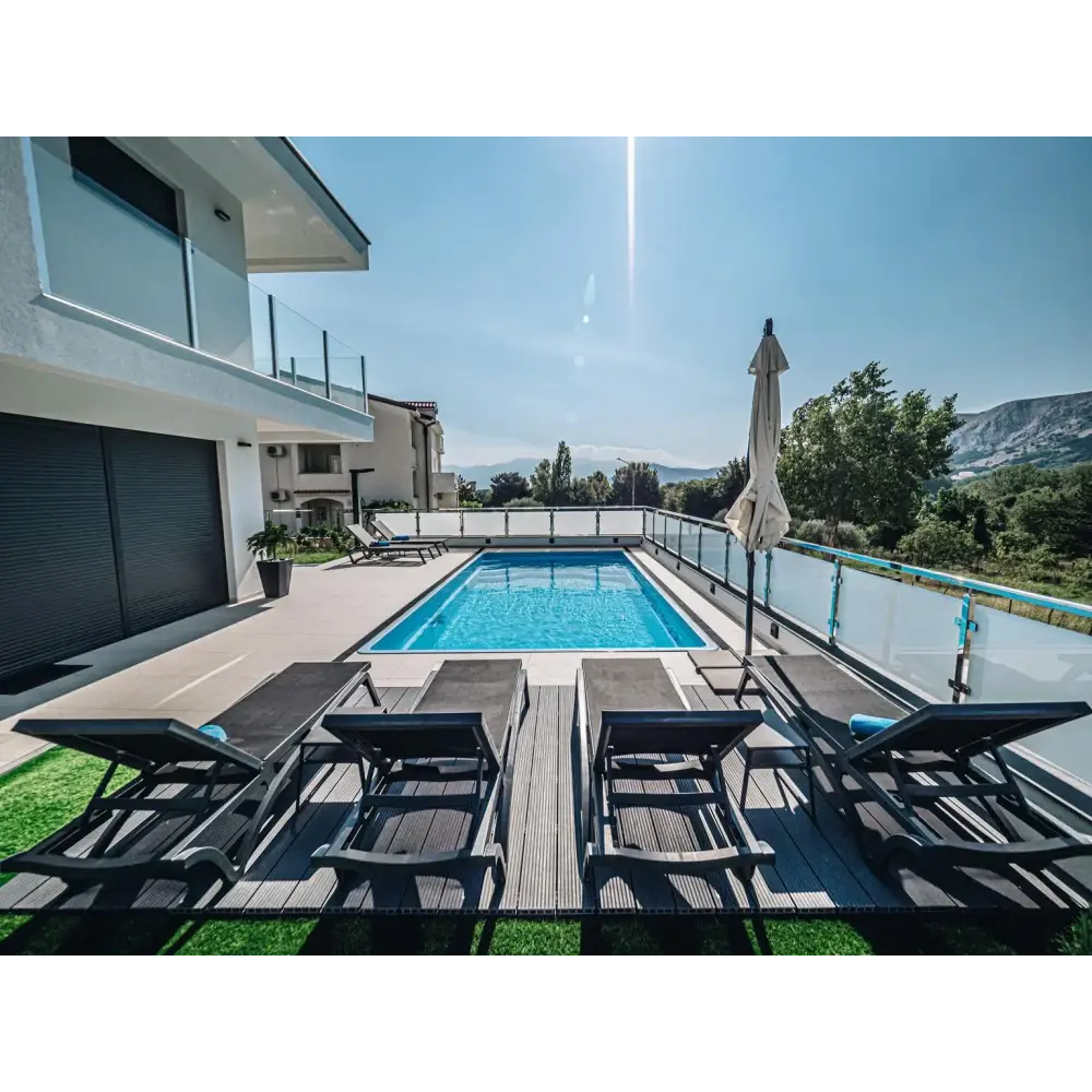 Rektangulär glasfiberpool Aruba Plus med blått klart vatten och glasräcke