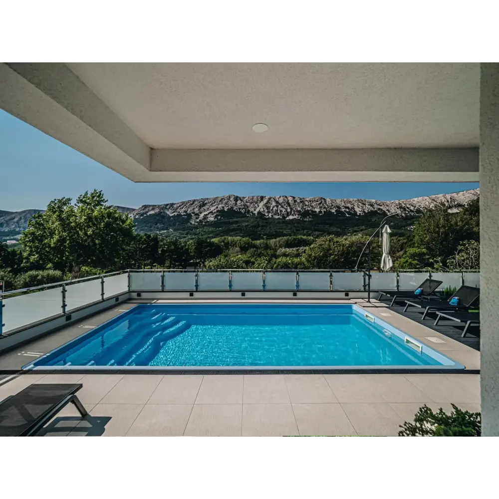 Rektangulär glasfiberpool Aruba Plus med klart blått vatten och grå kant