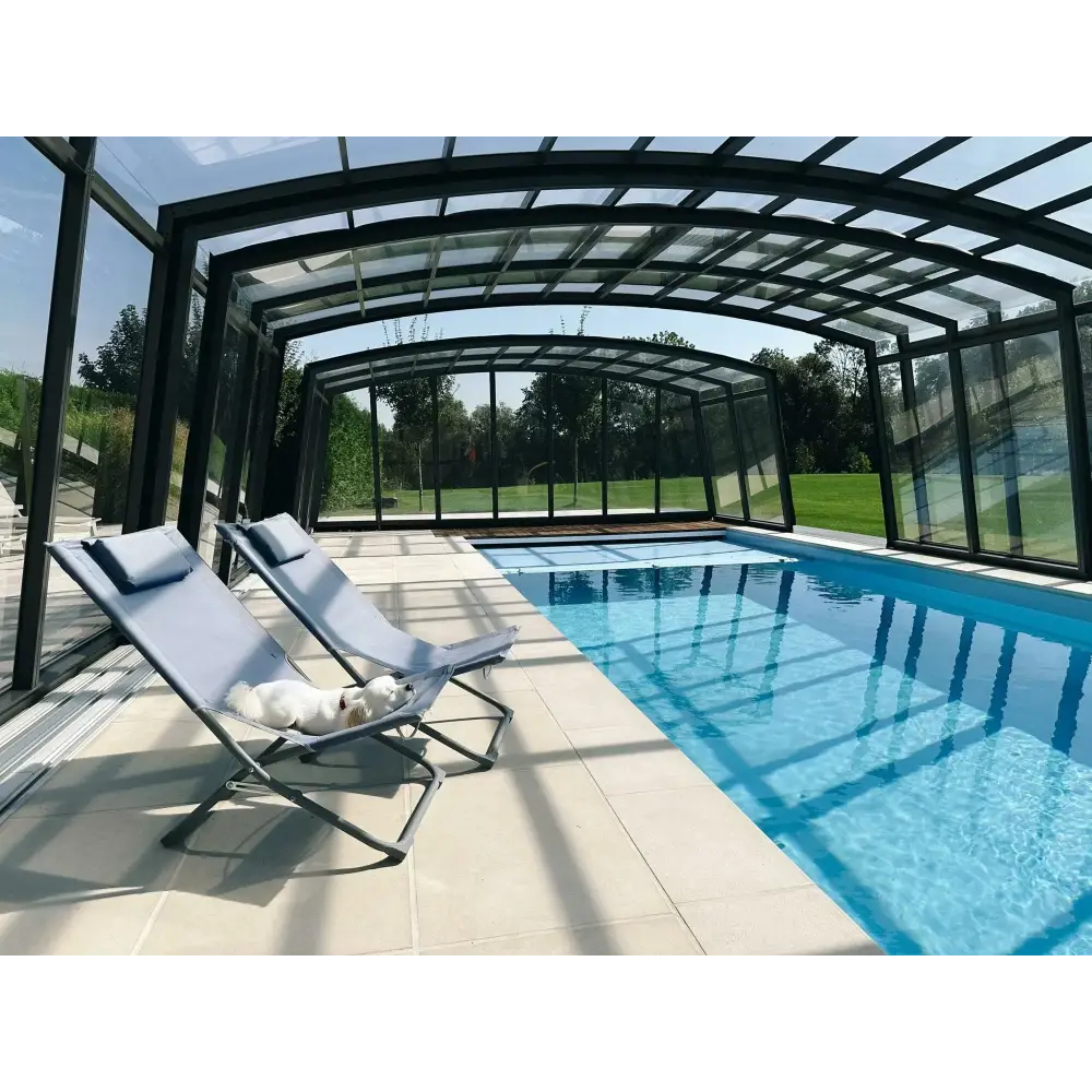 Ljusblå tygfåtölj med metallram vid Bahama trädgårdspool med transparent pooltak