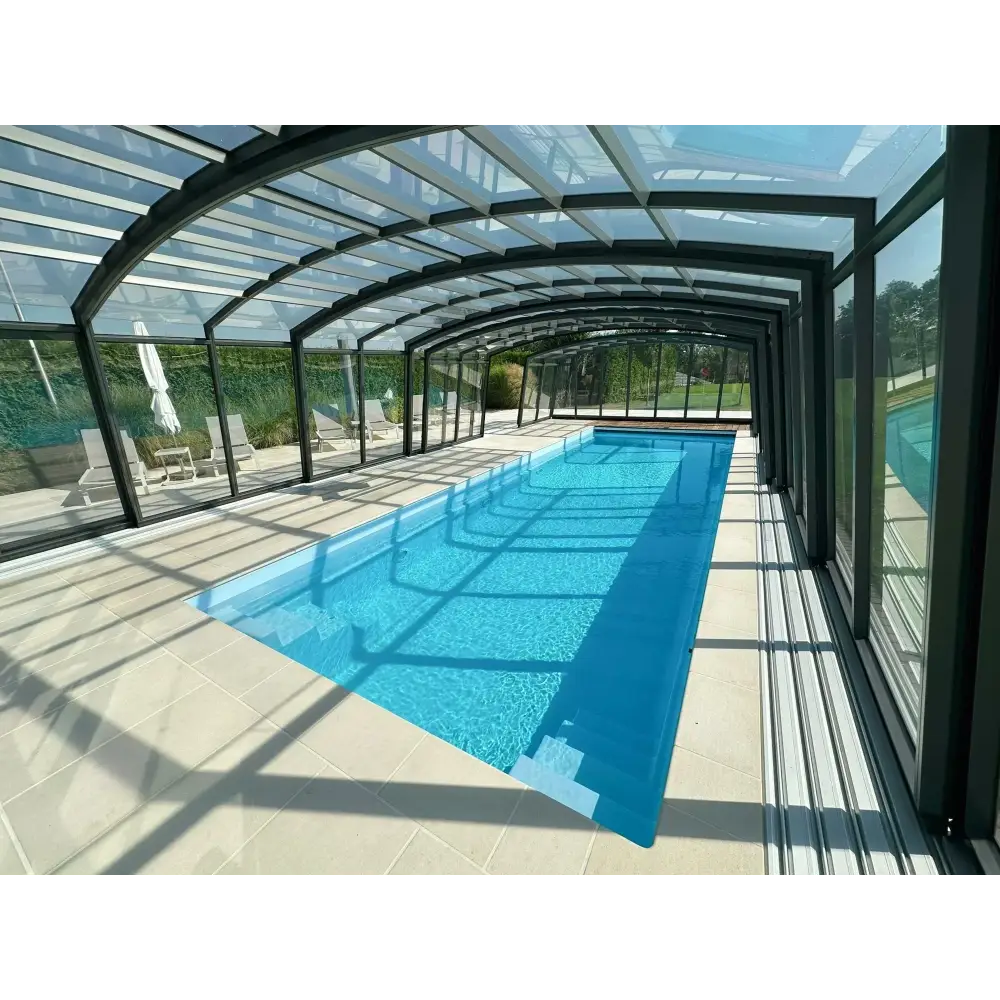 Lång rektangulär inomhuspool med Bahama trädgårdspool och transparent pooltak