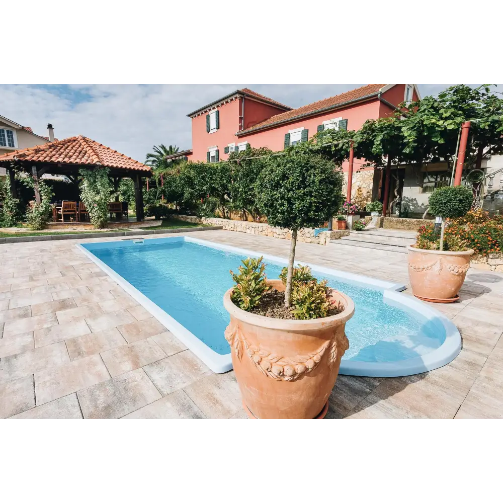 Glasfiberpool Haiti med avrundad trappa och terrakottakruka med träd