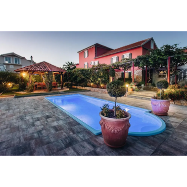 Terrakotta keramikkruka med dekorationer vid glasfiberpool Haiti och avrundad trappa i trädgårdspool