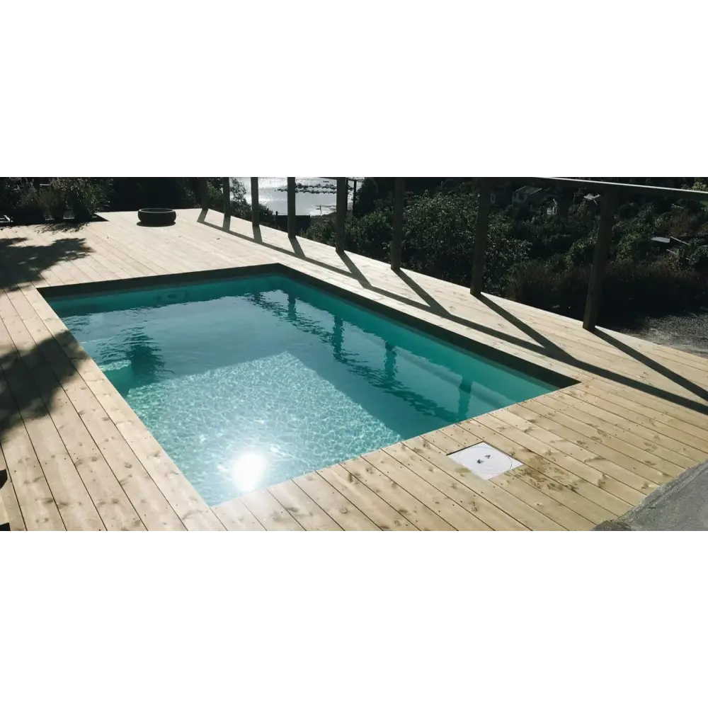 Glasfiberpool Mini Victoria med rektangulär form och klart turkost vatten omgivet av ljus trädeck