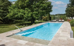 Leisurepools Definitive pool – high waterline, rectangular pool, clear blue water, beige stone paving