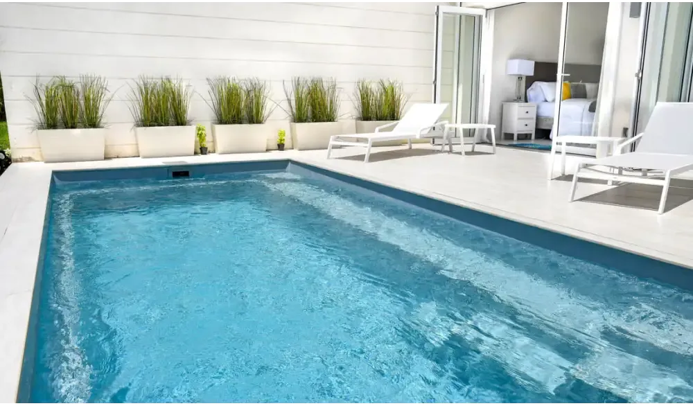 Rektangulär Leisurepools Harmony pool med klart blått vatten och betongkant