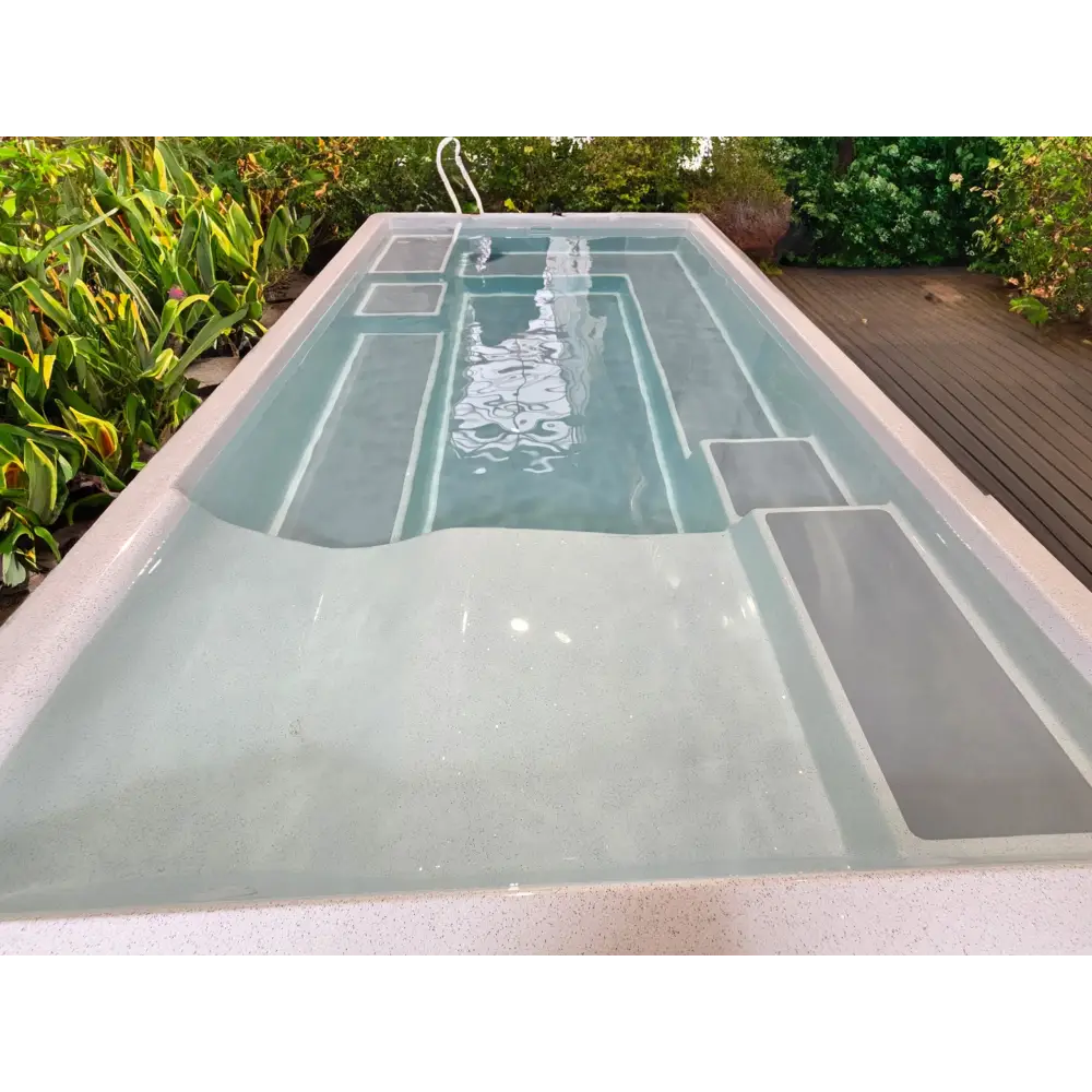 Rektangulär fiberglasspool Mira390 med ljusgrå interiör, inbyggda steg och grön omgivning för wellness pool ovanmark