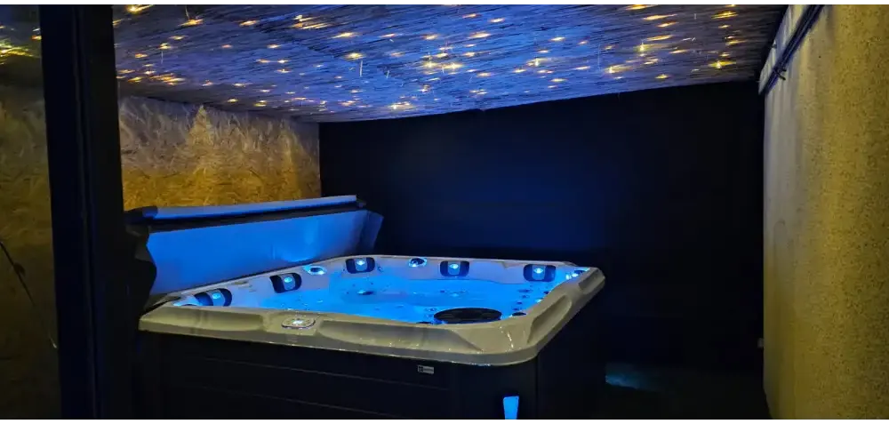 Blåupplyst PassionSpa Delight Spabad med vit-svarta accenter under stjärnhimmel