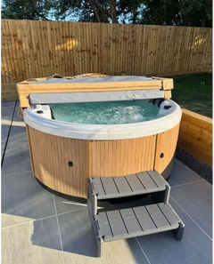 PassionSpa Recharge hot tub – wooden panel, grey fabric cover, bubbling water, turquoise water