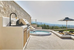 PassionSpa Recharge hot tub – Pure Collection, beige stone outdoor kitchen with a black tap and stainless steel barbecue