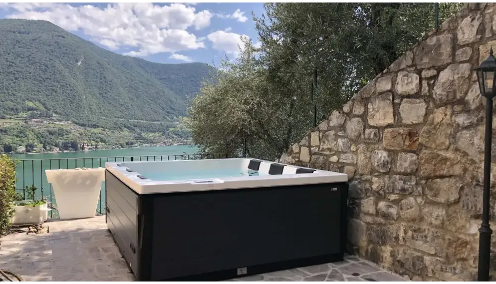 PassionSpa Serene 6 hot tub – fireplace, white and black, modern design, stone wall