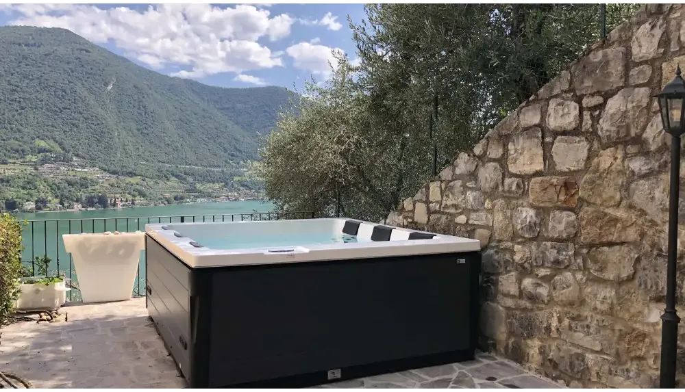 PassionSpa Serene 6 hot tub – fireplace, white and black, modern design, stone wall