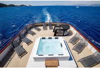 PassionSpa Serene 6 hot tub – white finish, fireplace, rectangular shape, clear blue water, black edge, on a boat deck