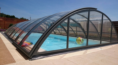 Classic pool enclosure with clear polycarbonate panels and anthracite profiles – lifestyle image of the model range.
