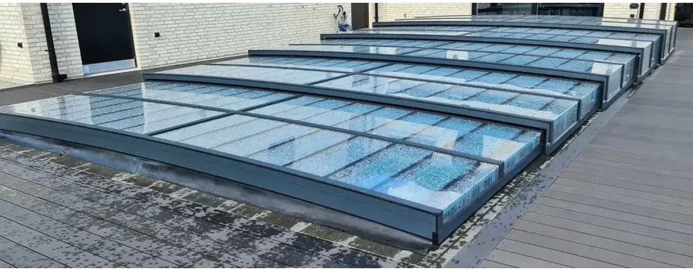 Moderna glastakpaneler med mörka metallramar i Pooltaket Icon med sarg klarplast antracit
