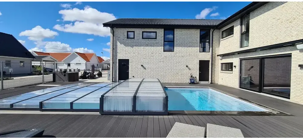 Modern klarplast antracit glastakpaneler på beige tegelhus