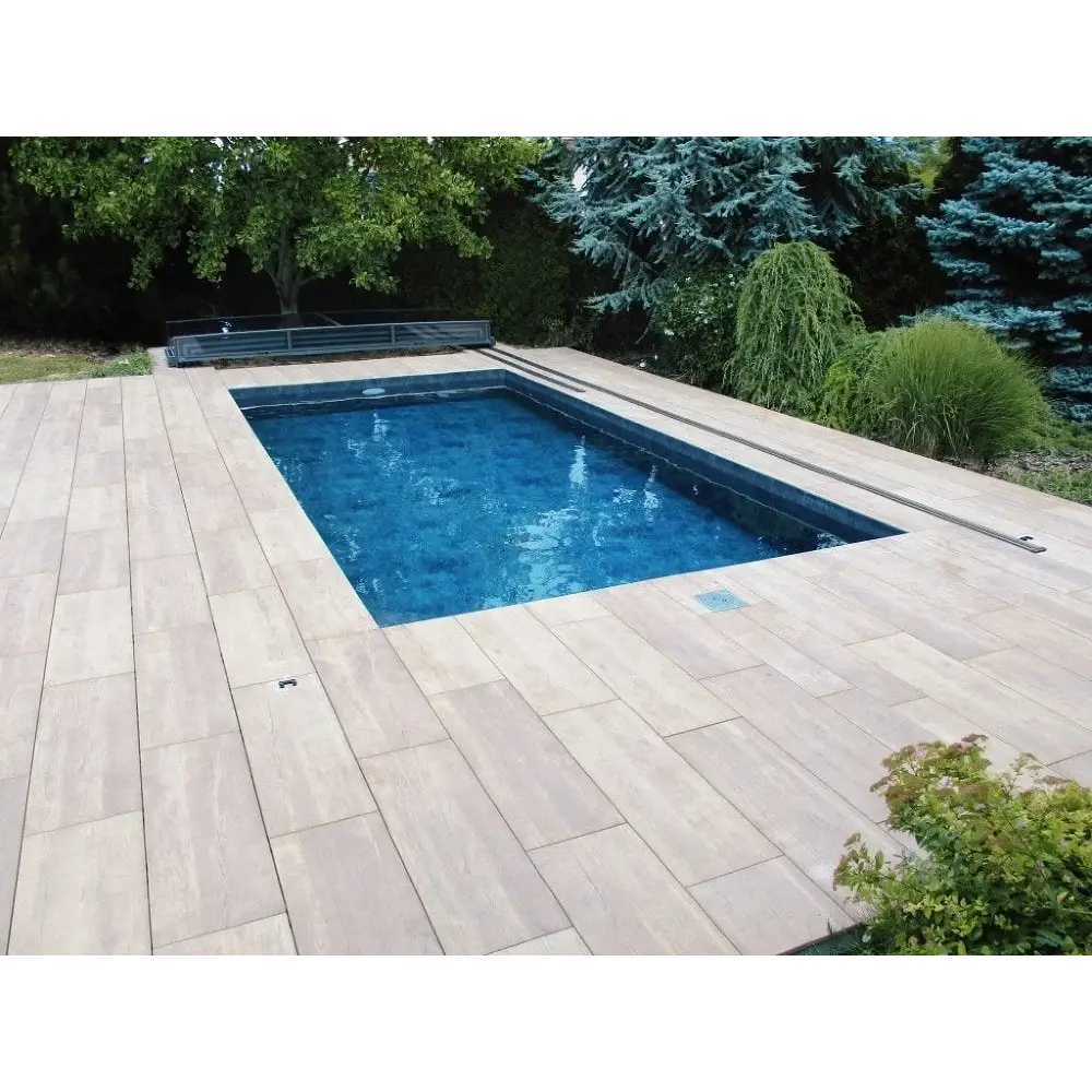 Rektangulärt pooltak Mästare Plus med klarblått vatten, trädeck och gröna träd