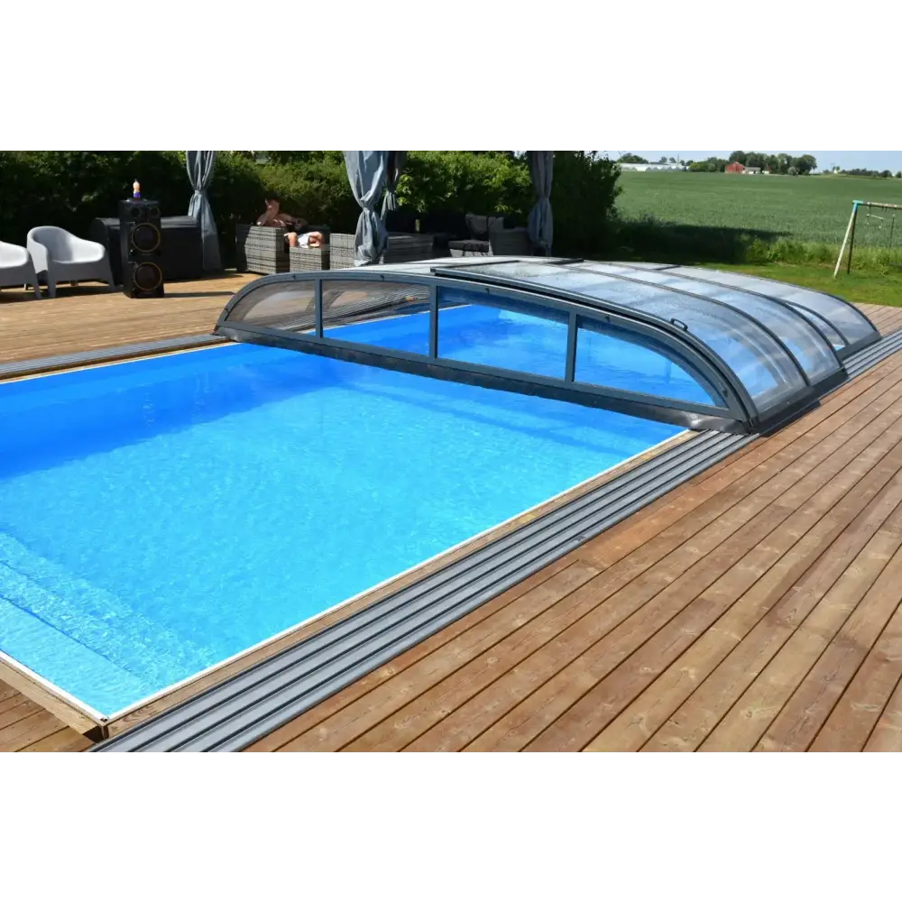 Blå inground pool med Pooltak Nivo Kit 1060B bågad täckning på trädeck