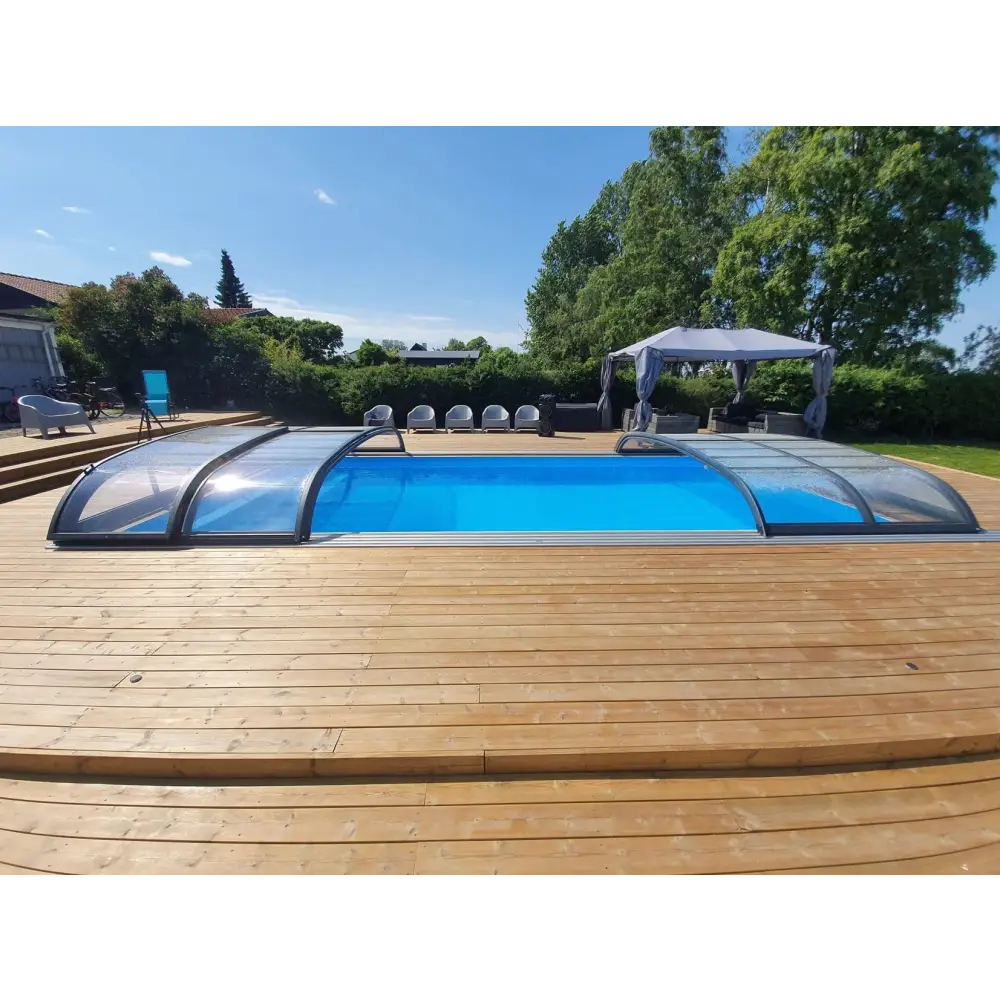 Blå pool med genomskinlig bågad pooltäckning i Pooltak Nivo Kit 1060B på trädeck