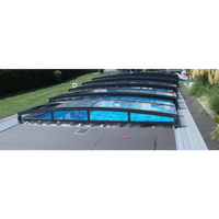 Pooltaket Special med RAL7016 antracit profiler, svart ramad med transparenta paneler över blå poolvatten