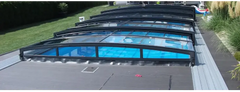 Special pool enclosure – RAL7016 anthracite profiles, black frame, curved clear panels, blue water visible beneath the panels