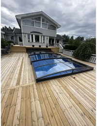 Elegant funktionellt pooltak Sydney med blå glas och svart ram på trädeck