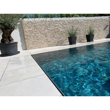 Pooltime Exclusive overflow med ljusgrå kaklad kant i turkosa vatten