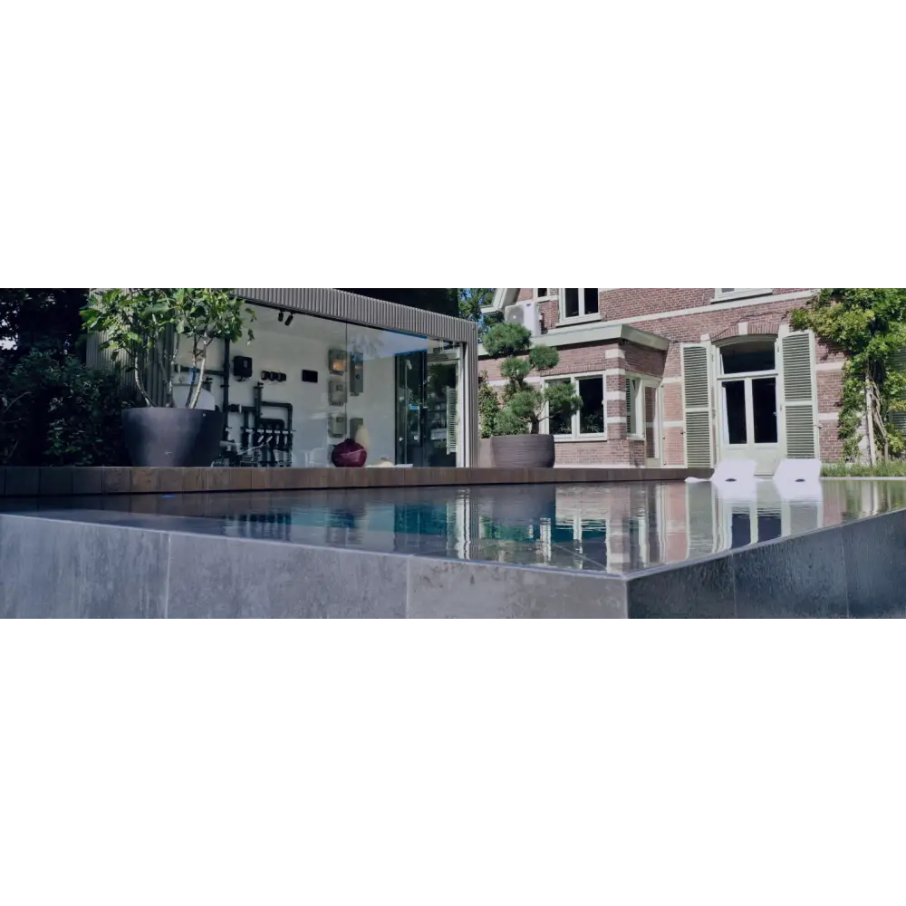 Exklusiv infinity pool med turkost vatten och svart kakel