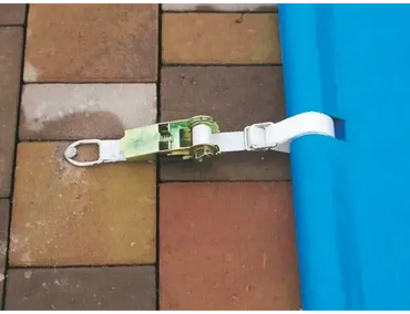 White strap for a blue pool cover, hand unit included – green and silver ratchet buckle