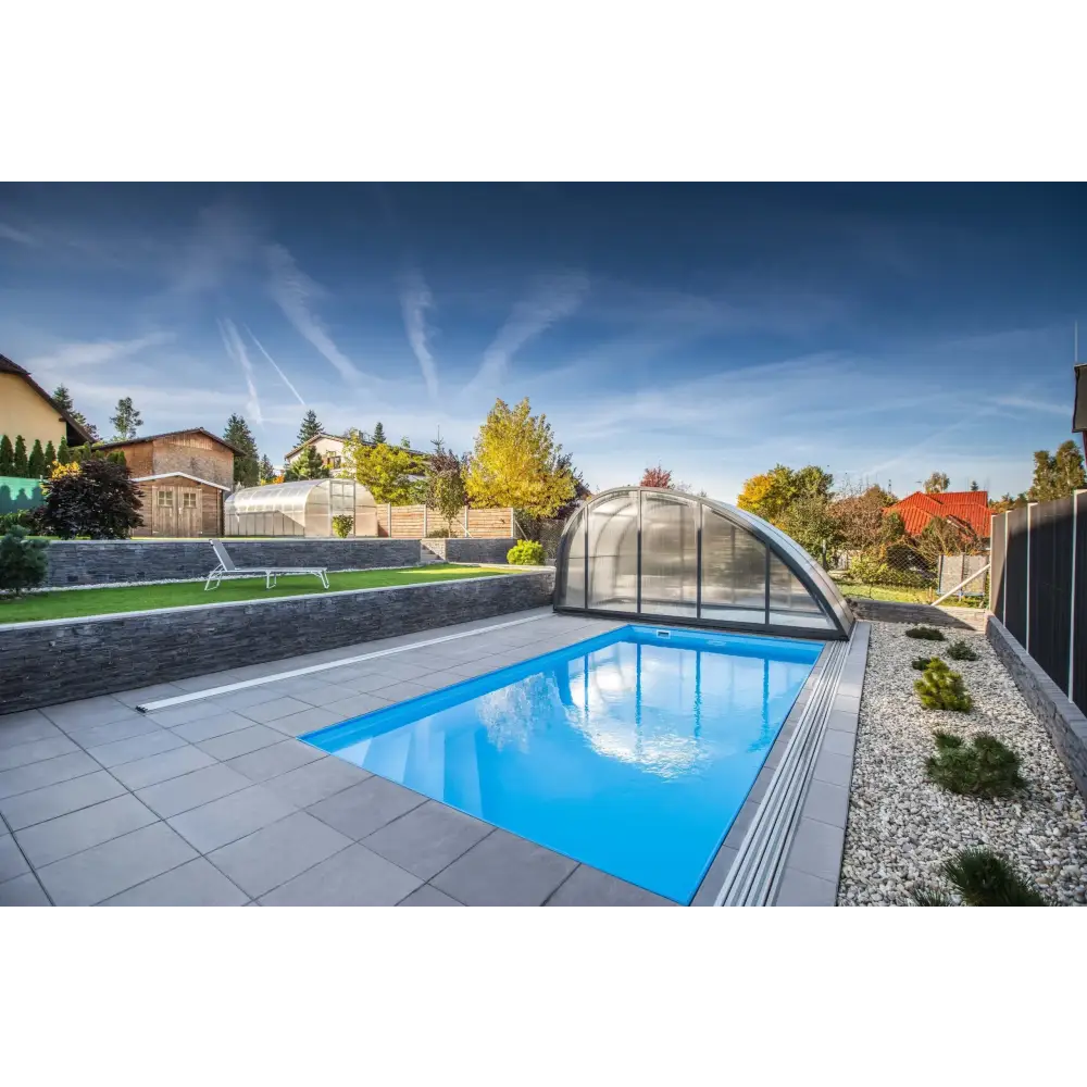 Modern blå rektangulär pool med transparent valv och grå stenplattor i Thermopp Poolpaket Qbig