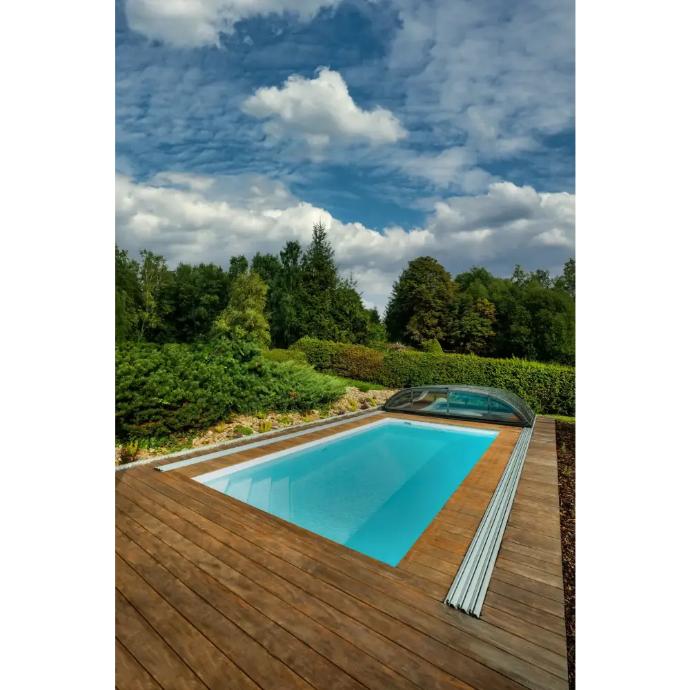 Rektangulär pool med klart blått vatten, trädeck och glasöverdrag för ekonomisk beredskap